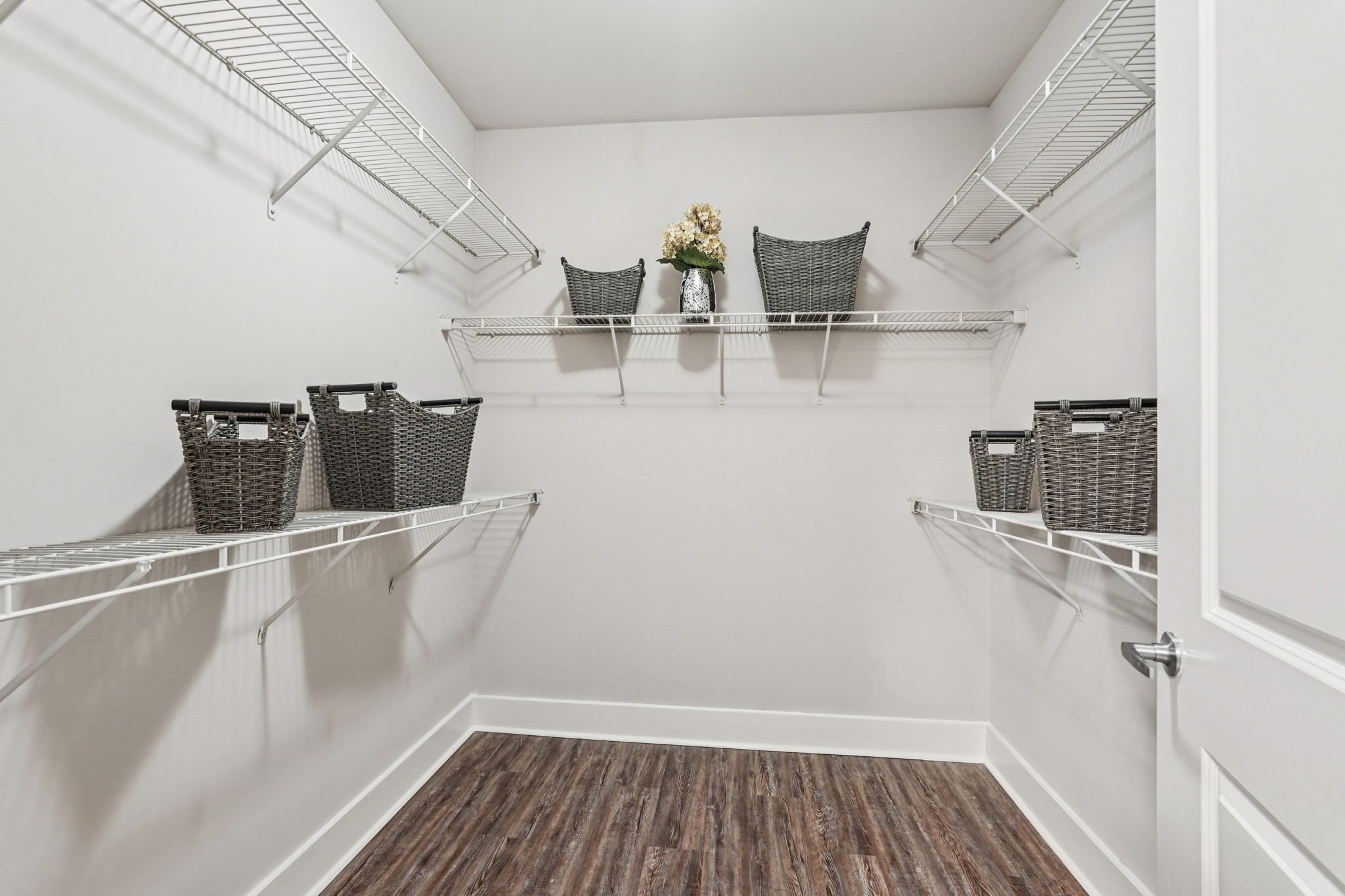 A white pantry with shelves and baskets.
